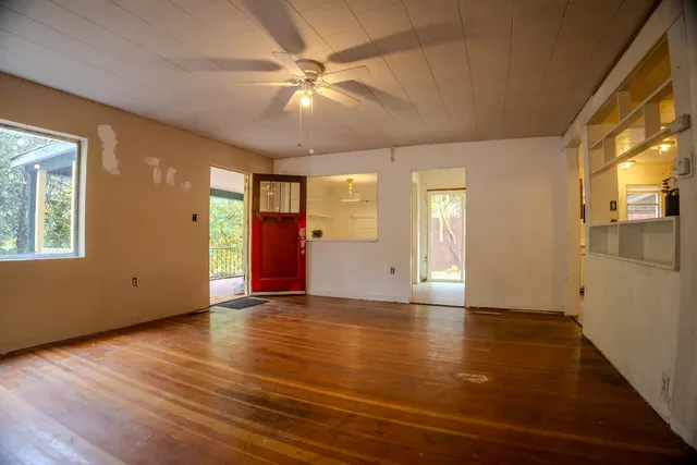 a view of a hallway with wooden floor and a room