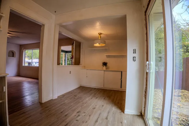 a view of a kitchen with refrigerator and wooden floor