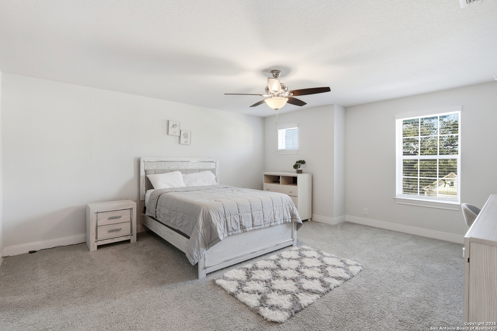 8334 Two Winds San Antonio, TX 78255 - Photo 21 of 39 a spacious bedroom with a bed and a chandelier