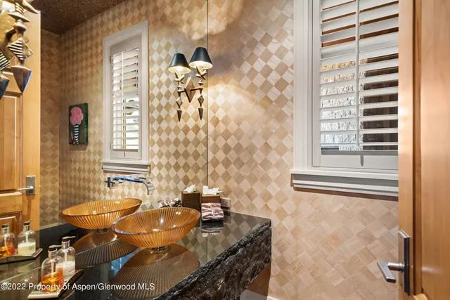a bathroom with a granite countertop sink a mirror and a shower