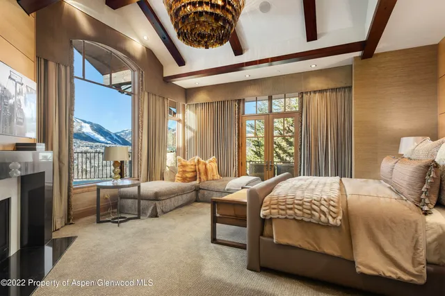 a bedroom with a bed couch and large window