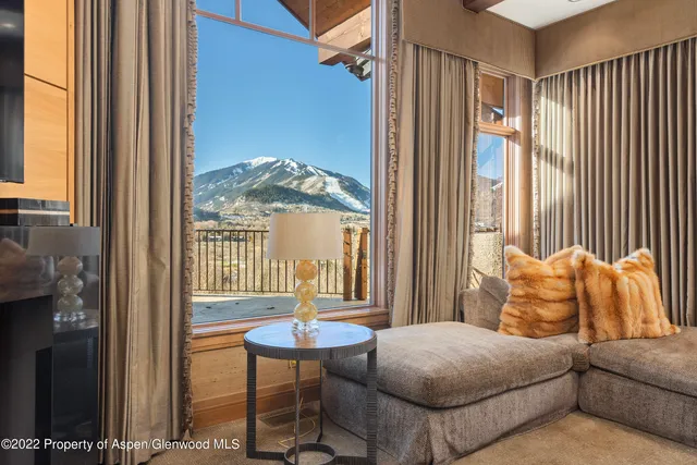 a living room with furniture a table and a large window