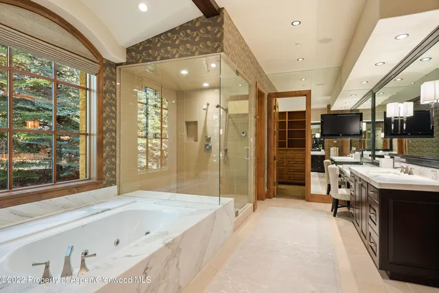 a spacious bathroom with a tub sink shower and mirror