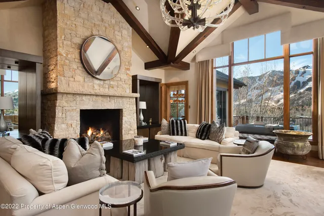 a living room with furniture a fireplace and a large window