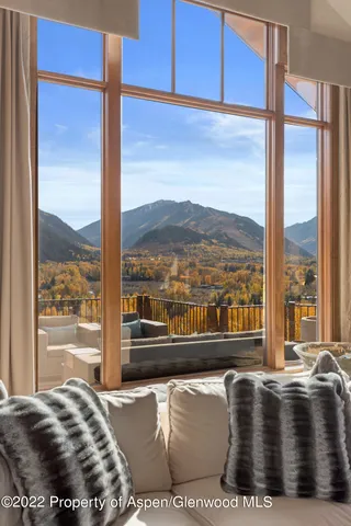 a living room with couches and floor to ceiling window