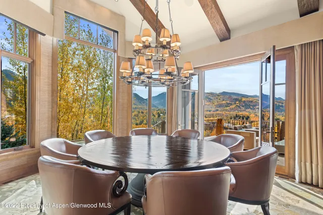a dining room with furniture a chandelier and wooden floor
