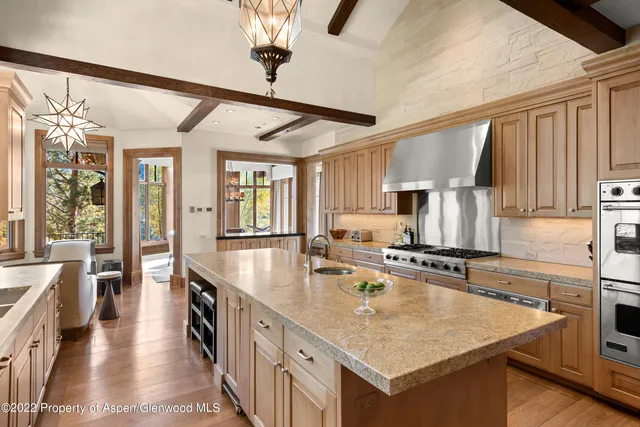 a kitchen with stainless steel appliances granite countertop a sink a stove and a refrigerator