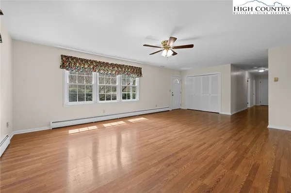 a view of empty room with wooden floor and ceiling fan