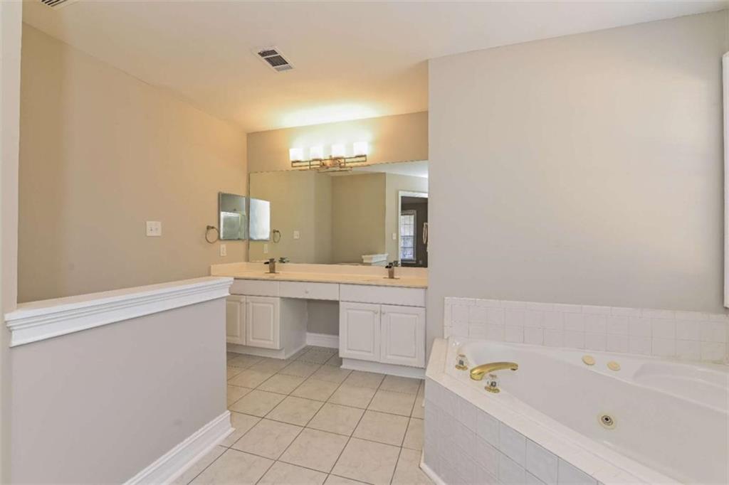 106 Emerald Lane Hampton, GA 30228 - Photo 16 of 19 a bathroom with a bathtub sink and mirror