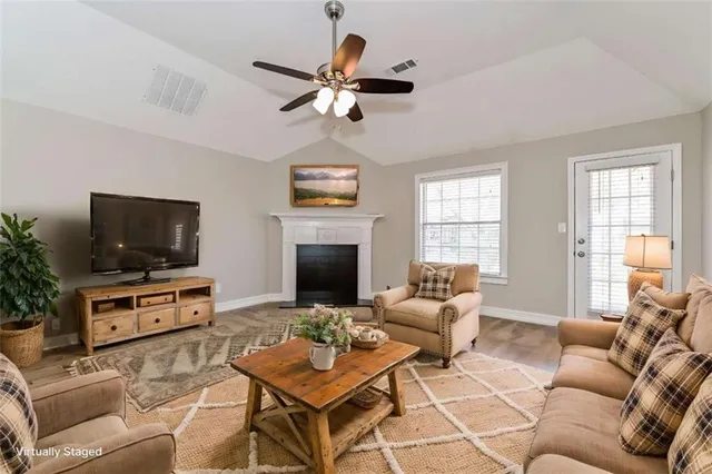 a living room with furniture a flat screen tv and a fireplace