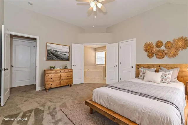 a spacious bedroom with a bed and a chandelier