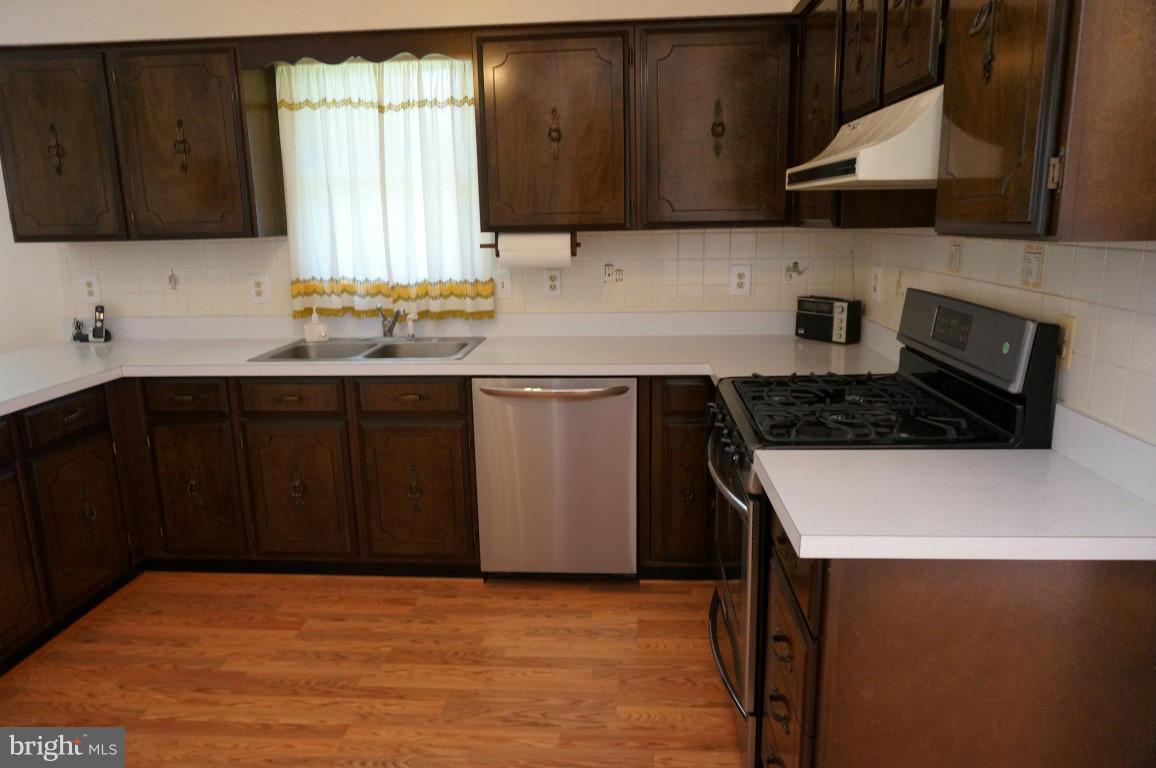 8611 McDaniel Road Baltimore, MD 21237 - Photo 4 of 21 a kitchen with a sink a stove and cabinets