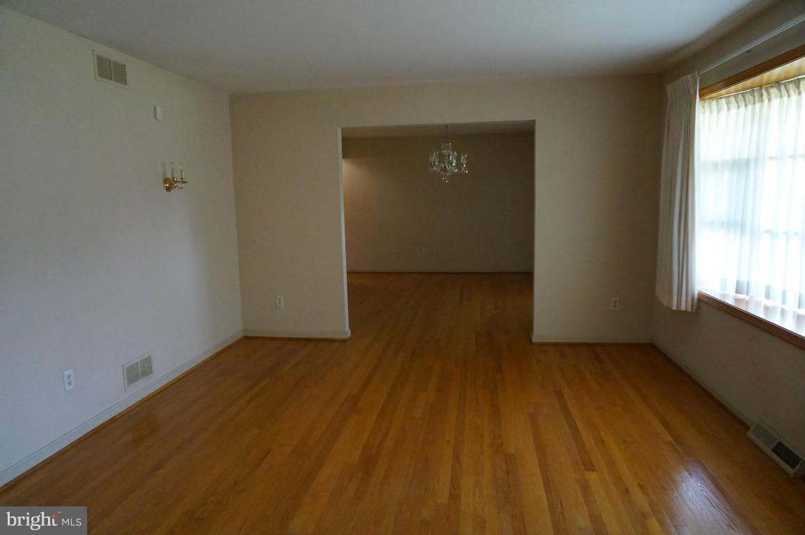 8611 McDaniel Road Baltimore, MD 21237 - Photo 7 of 21 an empty room with wooden floor and windows