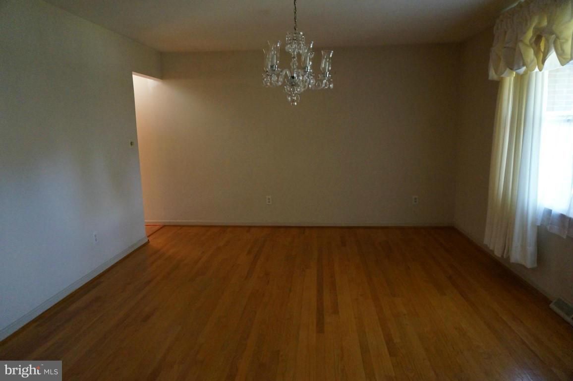 8611 McDaniel Road Baltimore, MD 21237 - Photo 8 of 21 a view of a room with wooden floor and chandelier