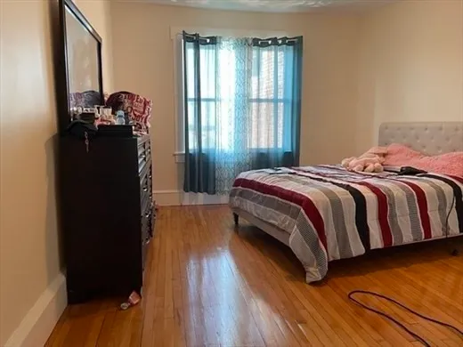 a bedroom with a bed and a large window