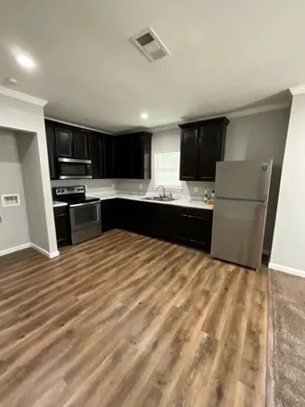 a kitchen with stainless steel appliances kitchen island granite countertop a refrigerator and a stove top oven