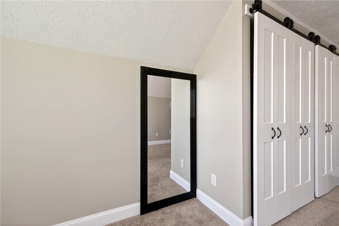 5975 Rosalie Road Dayton, OH 45424 - Photo 29 of 48 This cozy bedroom features sloped ceilings, plush carpet, and stylish barn door closets.