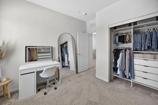 a view of walk in closet with clothes and shoes