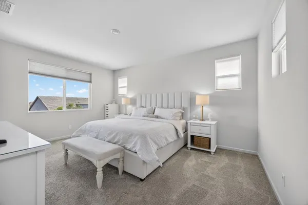 a living room with furniture a ceiling fan and a large window