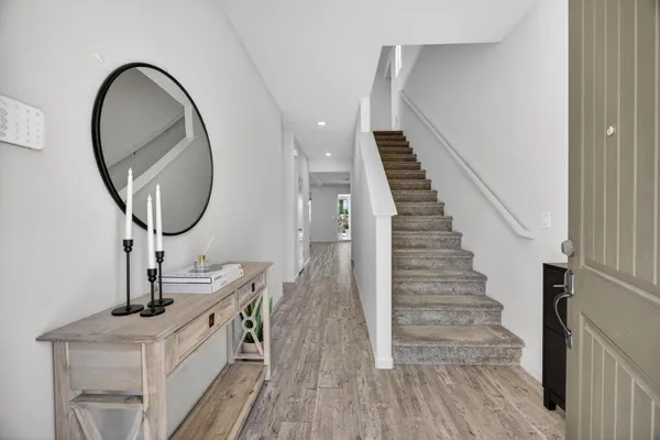 a view of a hallway with wooden floor and closet