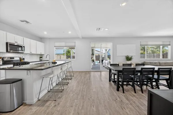a kitchen with white cabinets and chairs