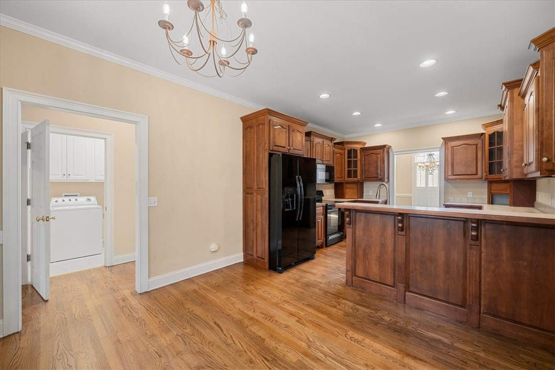 128 Cayman Way Anderson, SC 29621 - Photo 11 of 49 This spacious kitchen offers rich wood cabinetry, ample counter space, and durable hardwood flooring.