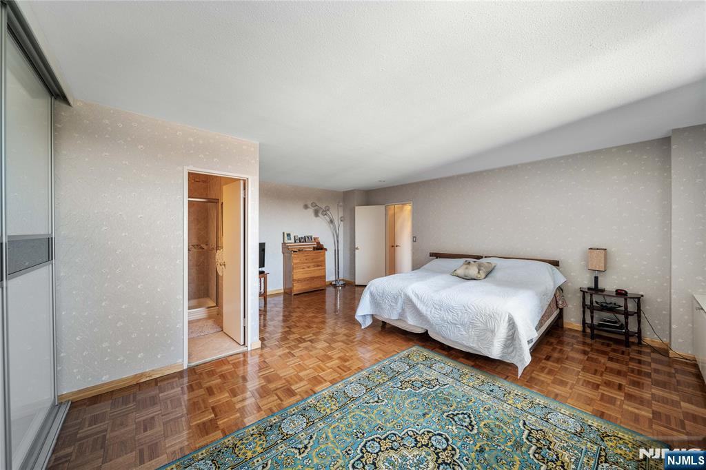 2200 North Central Road, Unit 6H Fort Lee, NJ 07024 - Photo 14 of 18 a spacious bedroom with a bed and a table in it