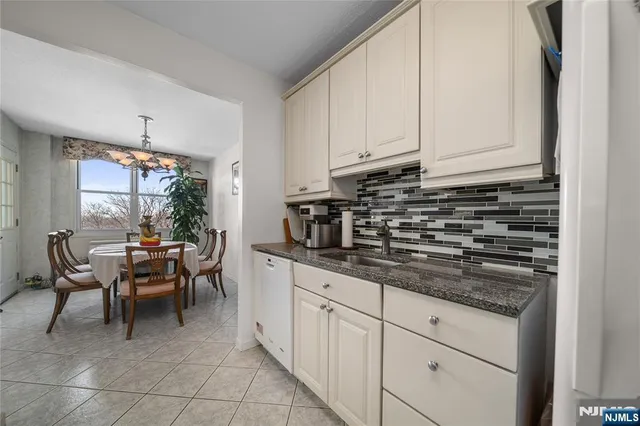 a kitchen with granite countertop white cabinets and stainless steel appliances