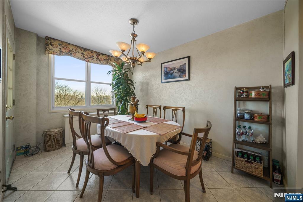 2200 North Central Road, Unit 6H Fort Lee, NJ 07024 - Photo 9 of 18 a view of a dining room with furniture a chandelier and window