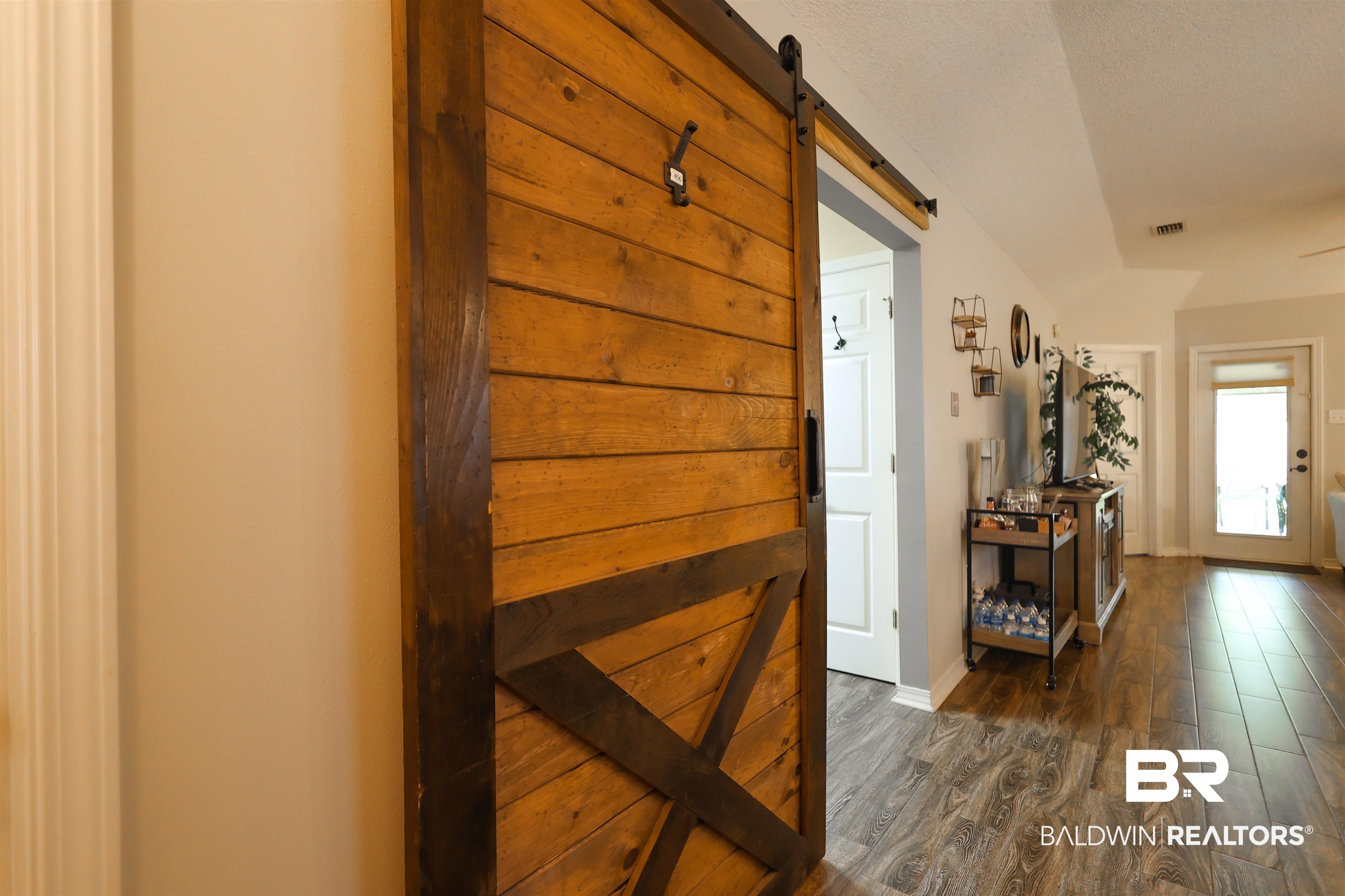 7790 Audubon Drive Foley, AL 36535 - Photo 7 of 39 Wood-finish flooring throughout the space, featuring a sliding barn door with dark hardware
