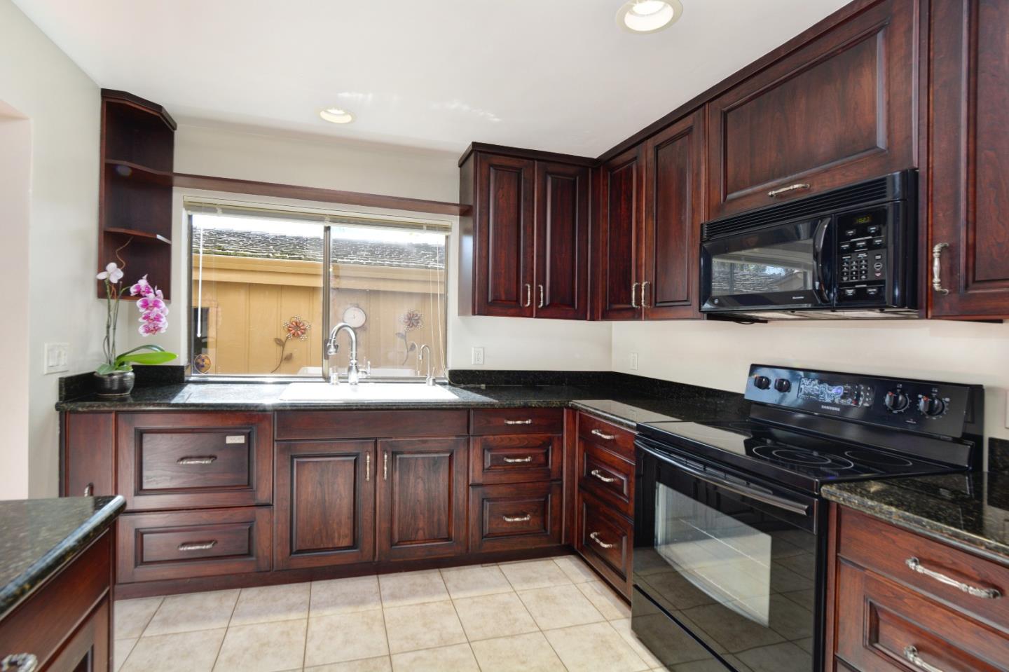 3850 Rio Road, Unit 40 Carmel, CA 93923 - Photo 12 of 28 a kitchen with granite countertop wooden cabinets and stainless steel appliances