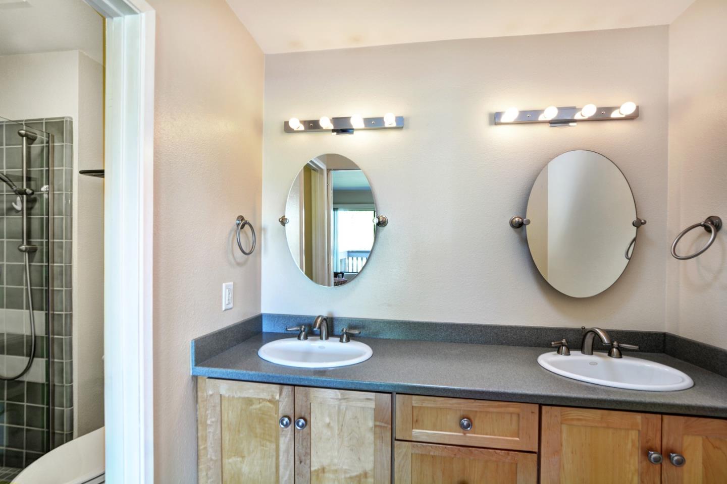 3850 Rio Road, Unit 40 Carmel, CA 93923 - Photo 21 of 28 a bathroom with a double vanity sink and a mirror