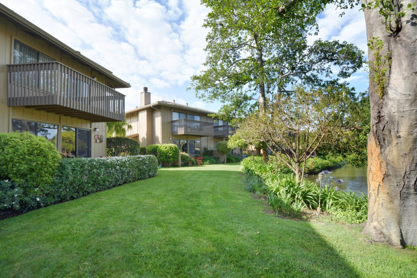 3850 Rio Road, Unit 40 Carmel, CA 93923 - Photo 25 of 28 a view of a house next to a big yard and large trees