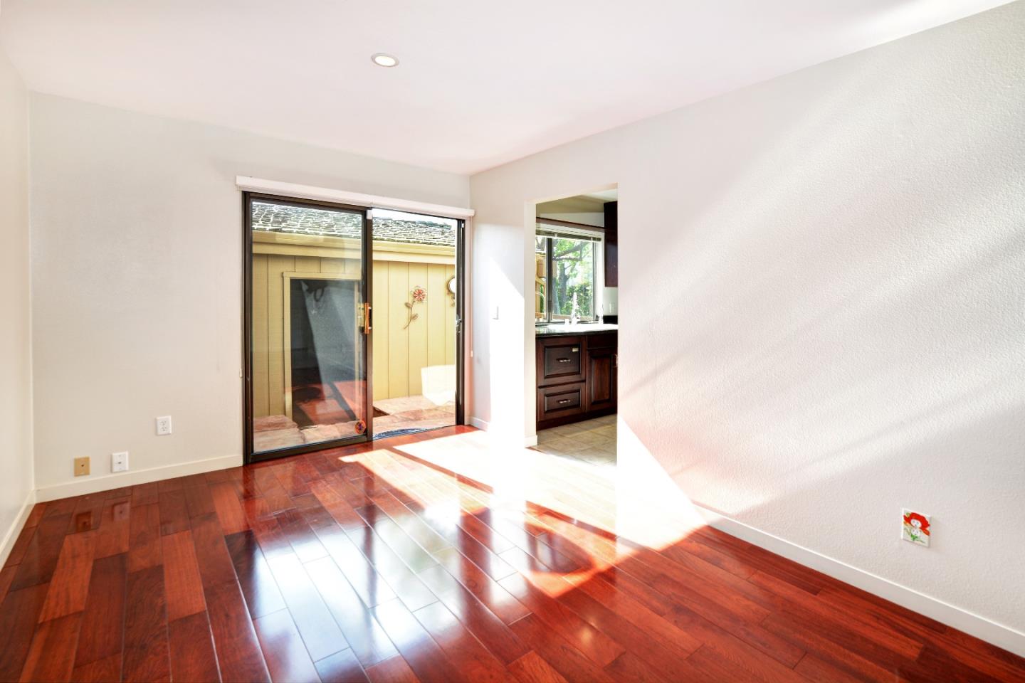 3850 Rio Road, Unit 40 Carmel, CA 93923 - Photo 9 of 28 a view of an empty room with wooden floor and a window