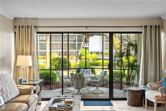 a living room with furniture and a floor to ceiling window