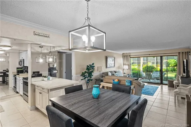 a view of a dining room with furniture a livingroom and chandelier