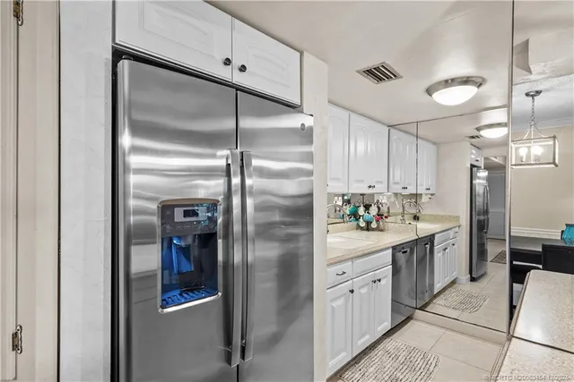 a kitchen with stainless steel appliances granite countertop a refrigerator and a sink