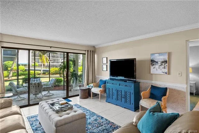 a living room with furniture a flat screen tv and a floor to ceiling window