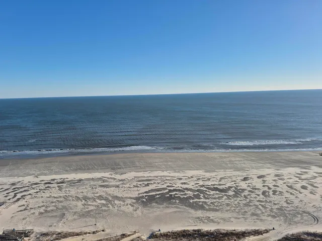 a view of a room with an empty space and wooden floor