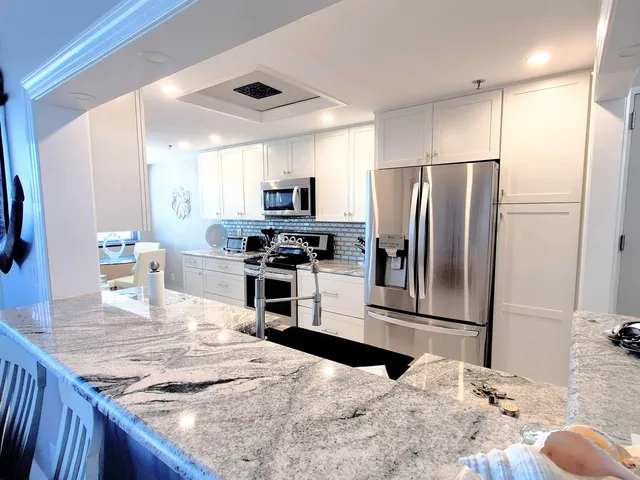 a kitchen with a refrigerator and a stove top oven