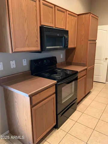 a kitchen with stainless steel appliances a stove a microwave and a white cabinets