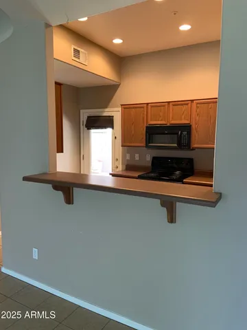 a view of kitchen with microwave and refrigerator