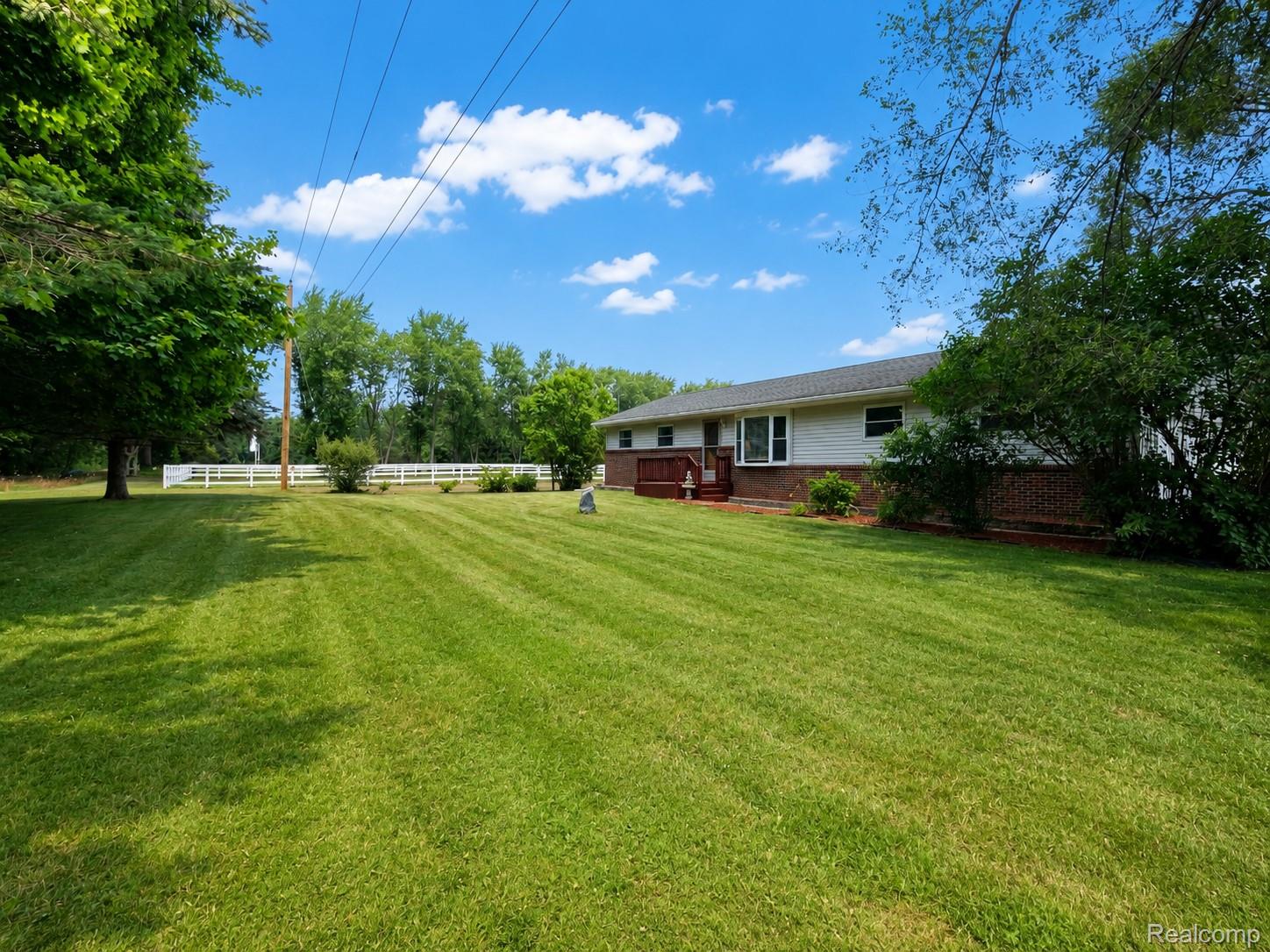 Expansive front lawn with mature trees