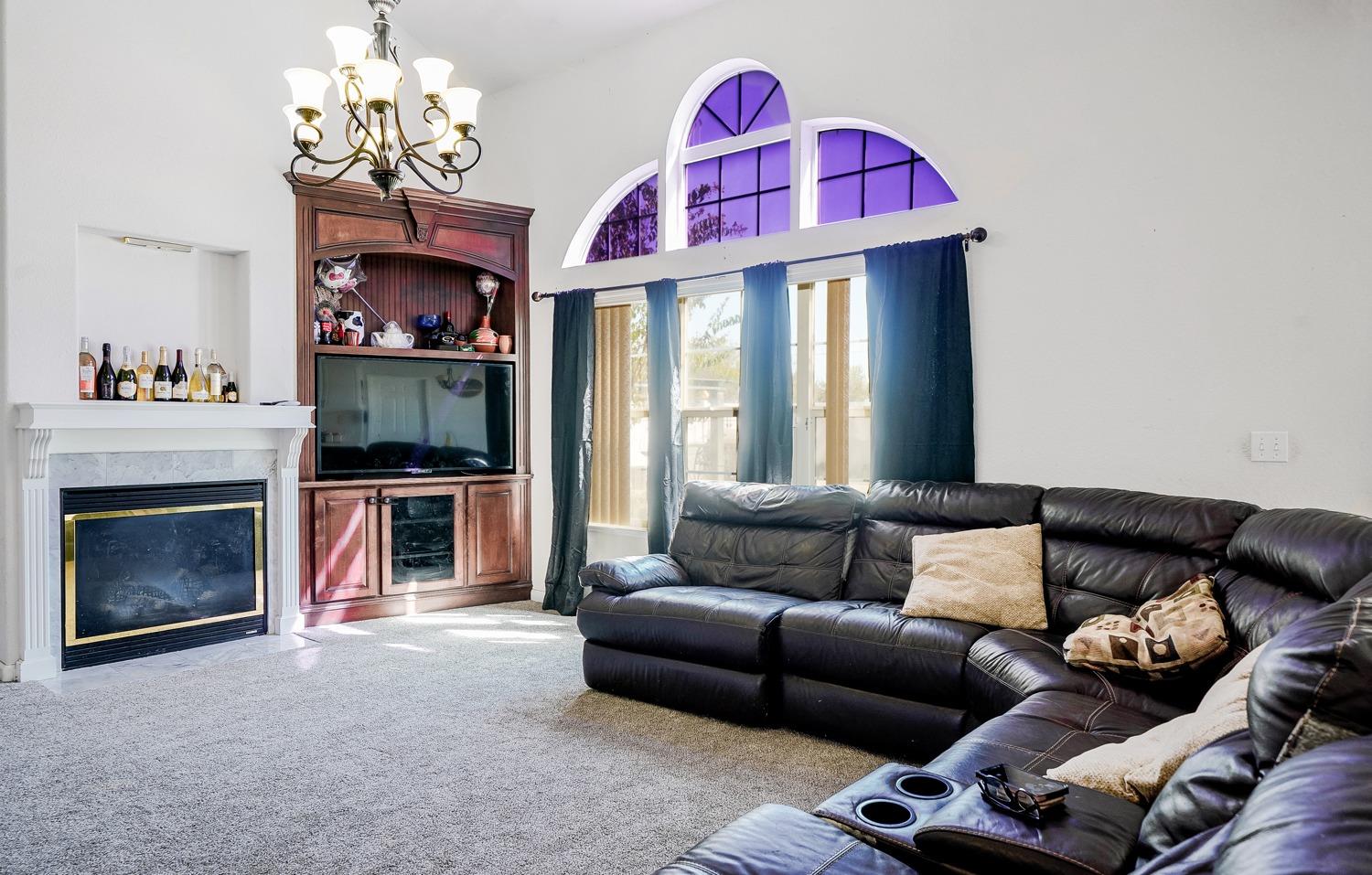 19360 Maple Street Laton, CA 93242 - Photo 13 of 53 a living room with furniture a fireplace and a chandelier