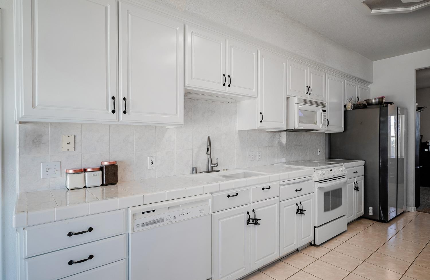 19360 Maple Street Laton, CA 93242 - Photo 19 of 53 a kitchen with cabinets appliances a sink and a counter space