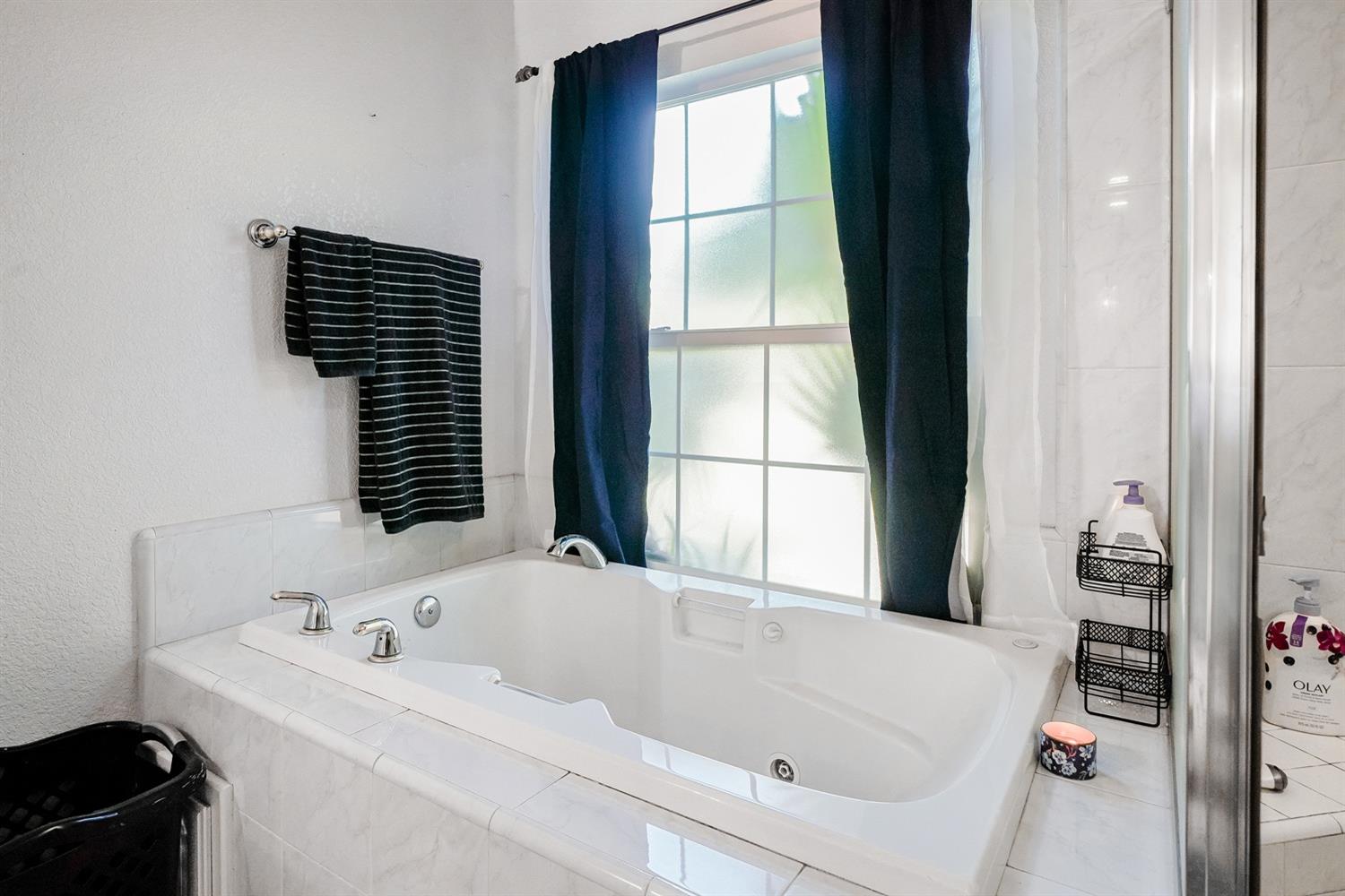 19360 Maple Street Laton, CA 93242 - Photo 24 of 53 a bathroom with a bathtub and a window