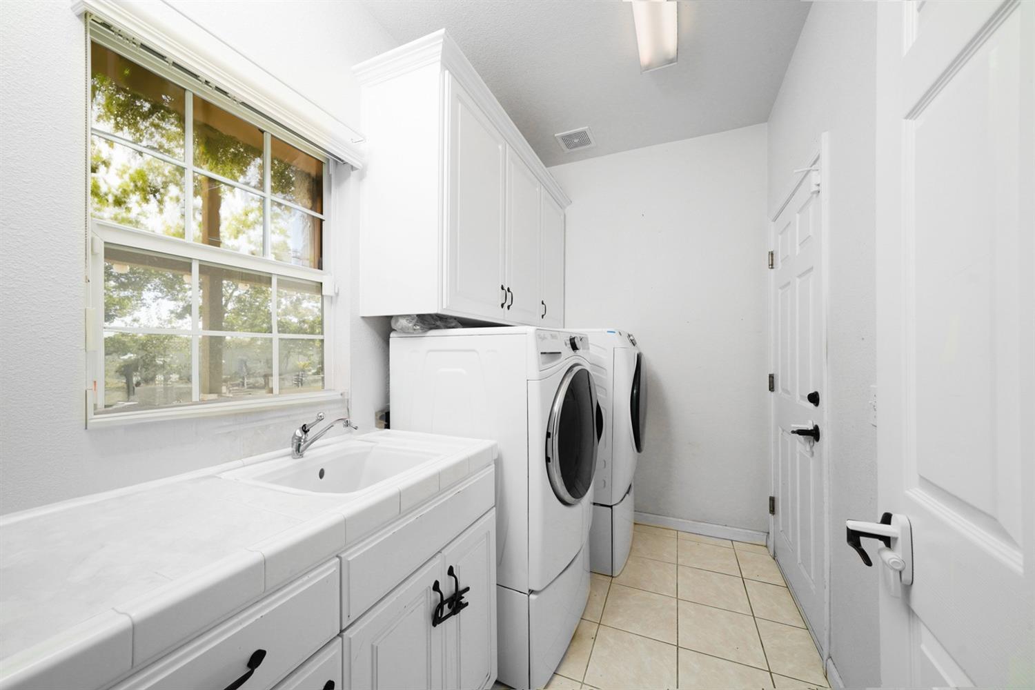 19360 Maple Street Laton, CA 93242 - Photo 32 of 53 a bathroom with a sink a washer and dryer next to a window
