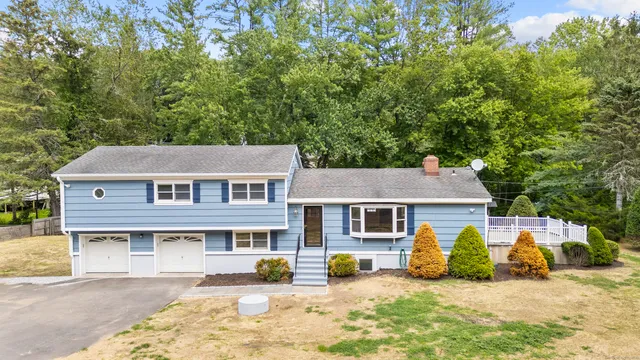 a front view of a house with a yard outdoor seating and house in the background