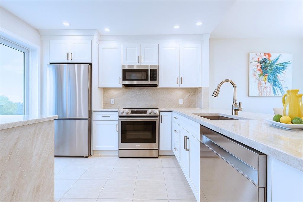 a kitchen with stainless steel appliances granite countertop a refrigerator sink and stove
