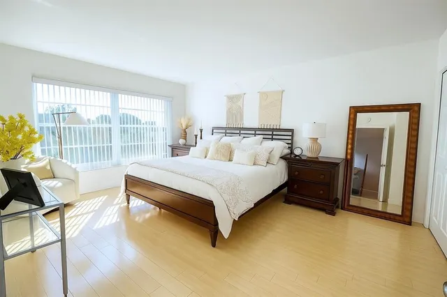 a bedroom with a bed and wooden floor